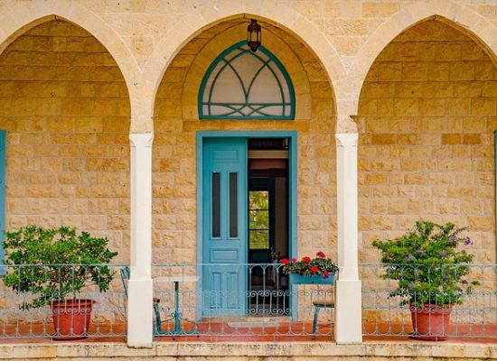 Front of a building with arched porch and blue doors